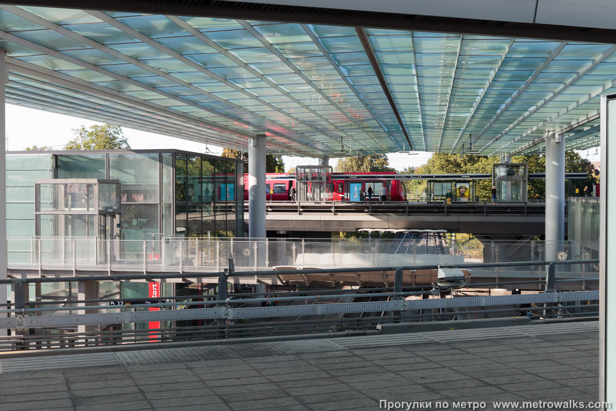 Фотография станции Flintholm [Флинтхольм] (Копенгаген). Поперечный вид. Рядом со станцией метро расположены станции двух линий S-tog (городской электрички): одна — почти параллельно, вторая — уровнем ниже, перпендикулярно.