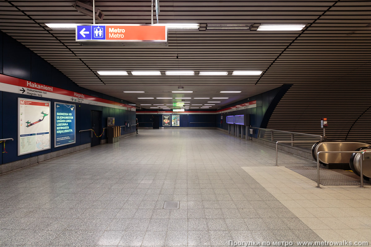 Фотография станции Hakaniemi / Hagnäs [Ха́каниэ́ми] (Хельсинки). Промежуточный зал между двумя группами эскалаторов. От эскалаторов с платформы (справа) к эскалаторам в подземный вестибюль под площадью Hakaniemi.