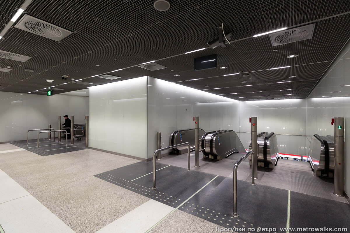 Фотография станции Tapiola / Hagalund [Та́пиола] (Хельсинки). Промежуточный зал между двумя группами эскалаторов. Третий ярус.