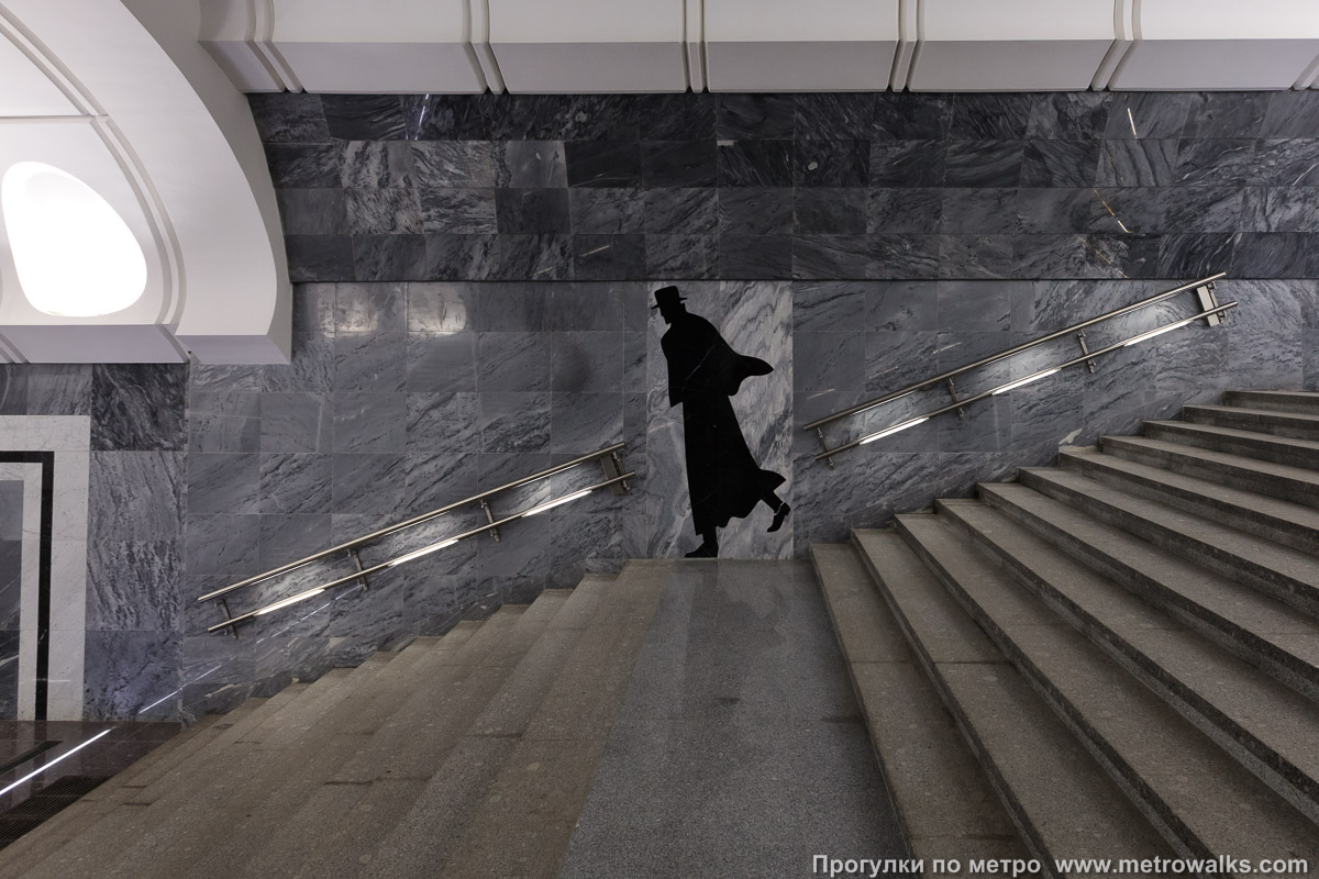 Фотография станции Достоевская (Люблинско-Дмитровская линия, Москва). Декоративная отделка стены в проходе к эскалаторам. И фигура чёрная.