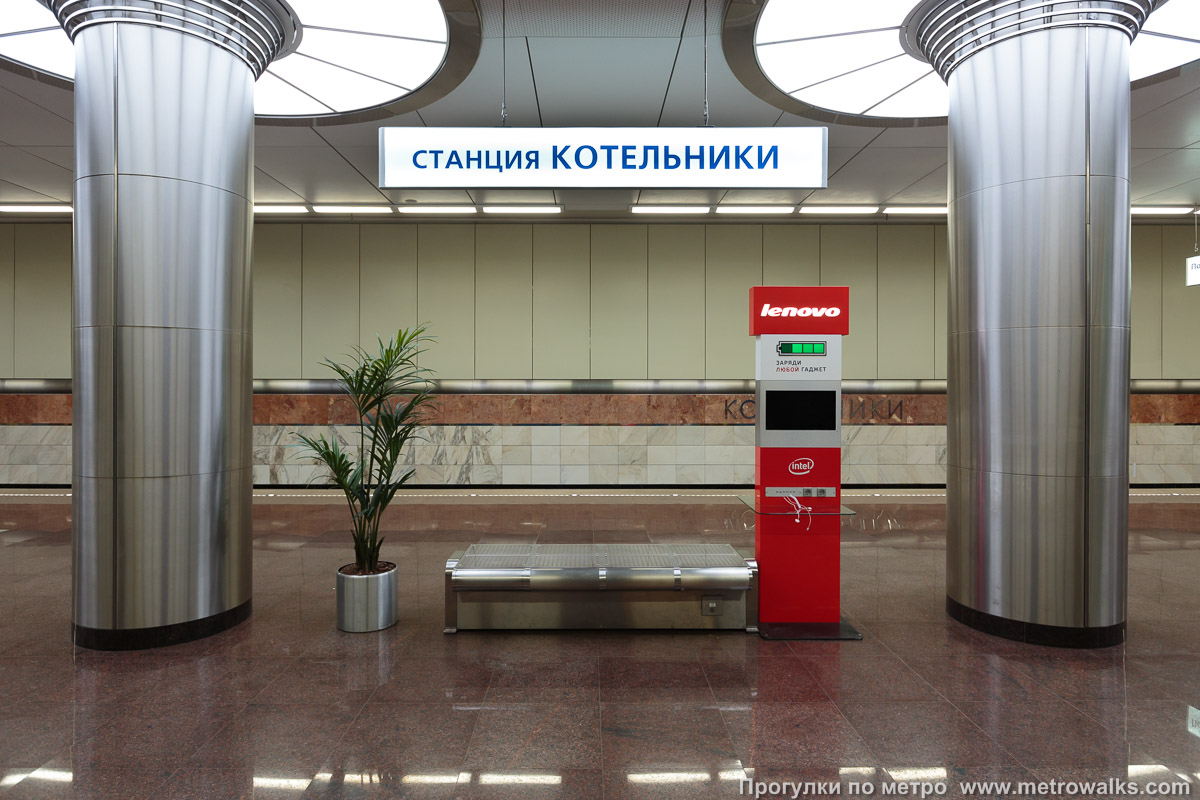 Фотография станции Котельники (Таганско-Краснопресненская линия, Москва). Поперечный вид. На станции установлен рекламный аппарат «Lenovo» для подзарядки мобильных телефонов.