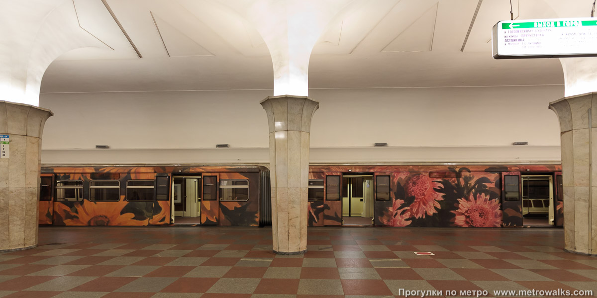 Фотография станции Кропоткинская (Сокольническая линия, Москва). Поперечный вид, проходы между колоннами из центрального зала на платформу. Поезд «Акварель» — нечастый гость на Сокольнической линии.