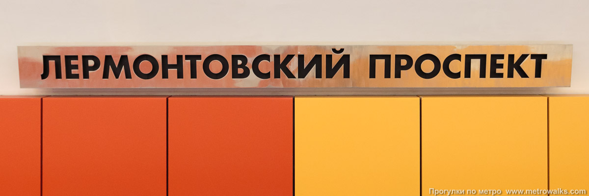 Фотография станции Лермонтовский проспект (Таганско-Краснопресненская линия, Москва). Название станции на путевой стене крупным планом. Красно-оранжевая часть станции.