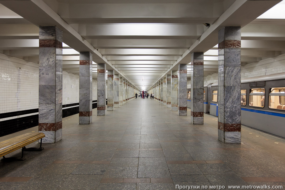 Фотография станции Молодёжная (Арбатско-Покровская линия, Москва). Продольный вид центрального зала. Мрамор на колоннах плавно меняет цвет от серого с одной стороны станции до бело-желтоватого с другой стороны.