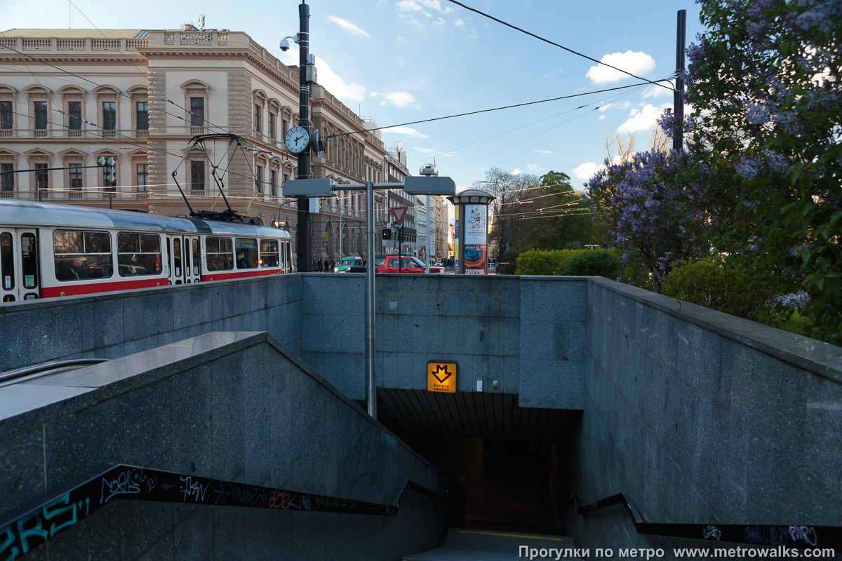Фотография станции Karlovo náměstí [Карлово на́мести] (линия B, Прага). Вход на станцию осуществляется через подземный переход. Спуски в подземный переход расположены по всем углам перекрёстка у площади.