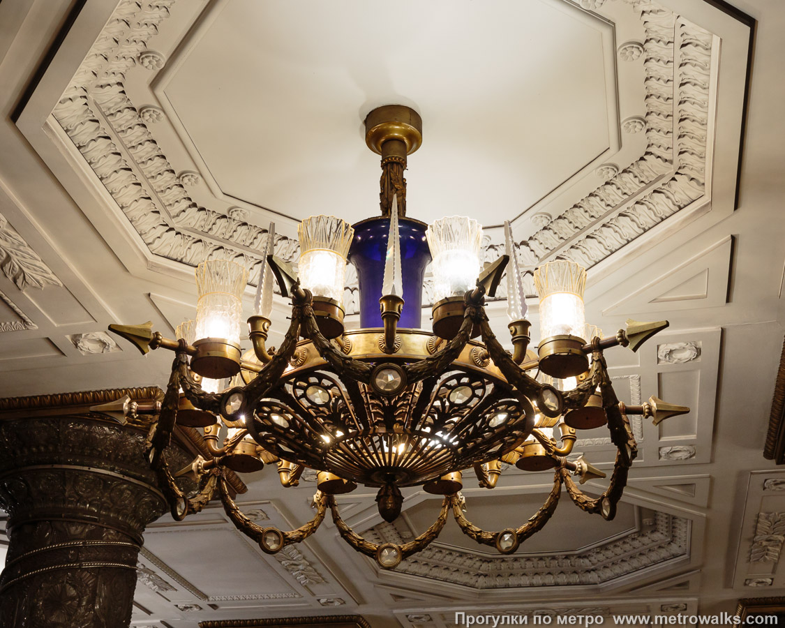 Фотография станции Автово (Кировско-Выборгская линия, Санкт-Петербург). Светильник крупным планом. Хрустальная инкрустация должна была разлагать непрерывный спектр ламп накаливания на маленькие радуги, но с заменой ламп на энергосберегающие с ущербным спектром эффект полностью пропал.