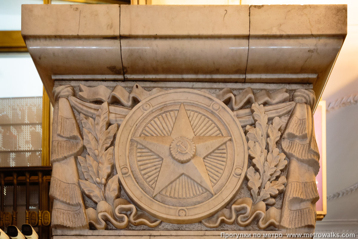 Фотография станции Автово (Кировско-Выборгская линия, Санкт-Петербург). Фрагмент декоративного оформления прохода к выходу крупным планом. Рыжий натриевый свет в художественно-архитектурной подсветке совершенно неуместен.
