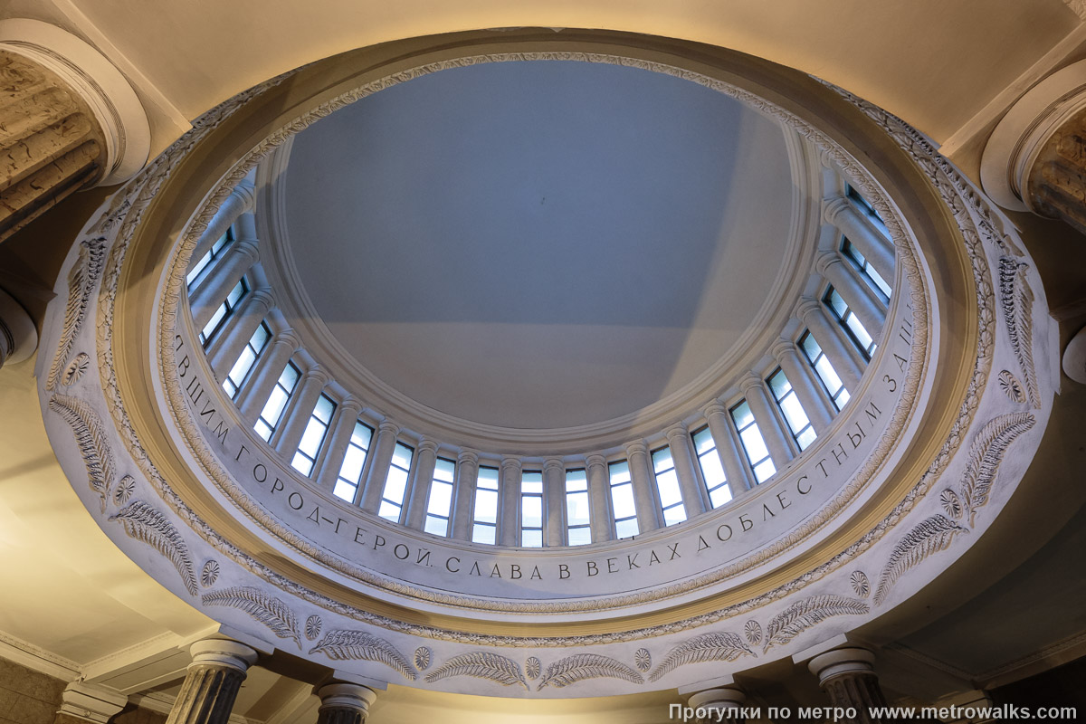 Фотография станции Автово (Кировско-Выборгская линия, Санкт-Петербург). Потолок вестибюля. Чтобы полностью прочитать на куполе прославление «СЛАВА В ВЕКАХ ДОБЛЕСТНЫМ ЗА… …ВШИМ ГОРОД-ГЕРОЙ», нужно найти точки в двух противоположных углах вестибюля.
