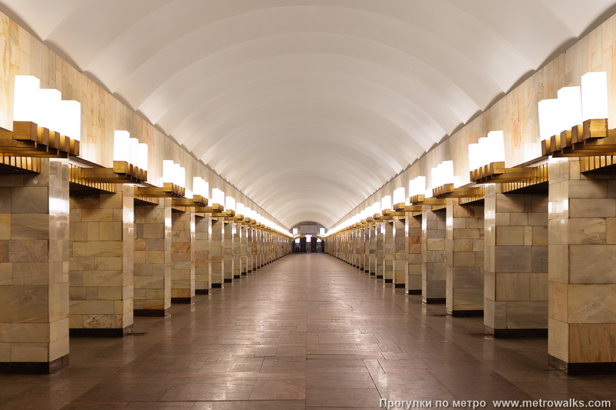 Фотография станции Гражданский проспект (Кировско-Выборгская линия, Санкт-Петербург). Центральный зал станции, вид вдоль от глухого торца в сторону выхода. Длиннофокусный ракурс со вниманием к колонным секциям.