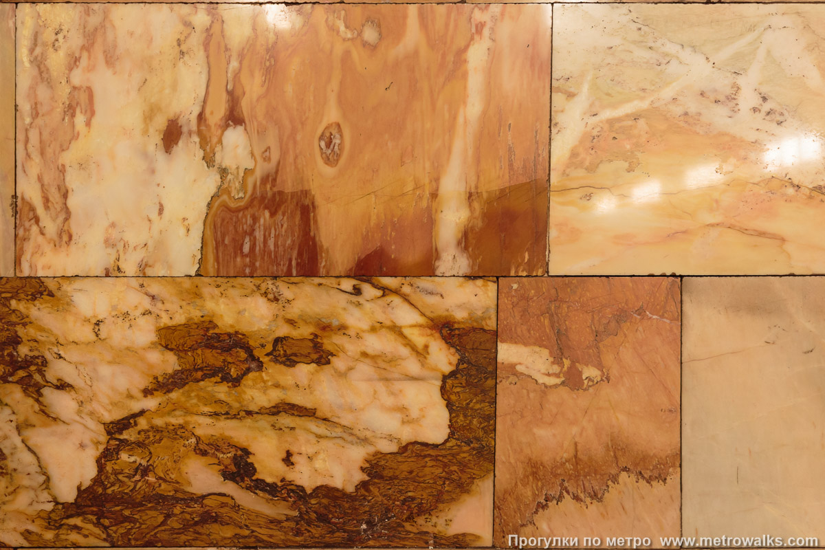 Фотография станции Гражданский проспект (Кировско-Выборгская линия, Санкт-Петербург). Фрагмент облицовки колонны крупным планом. Мрамор «Газган» разнообразен, его цвет на разных колоннах очень отличается.