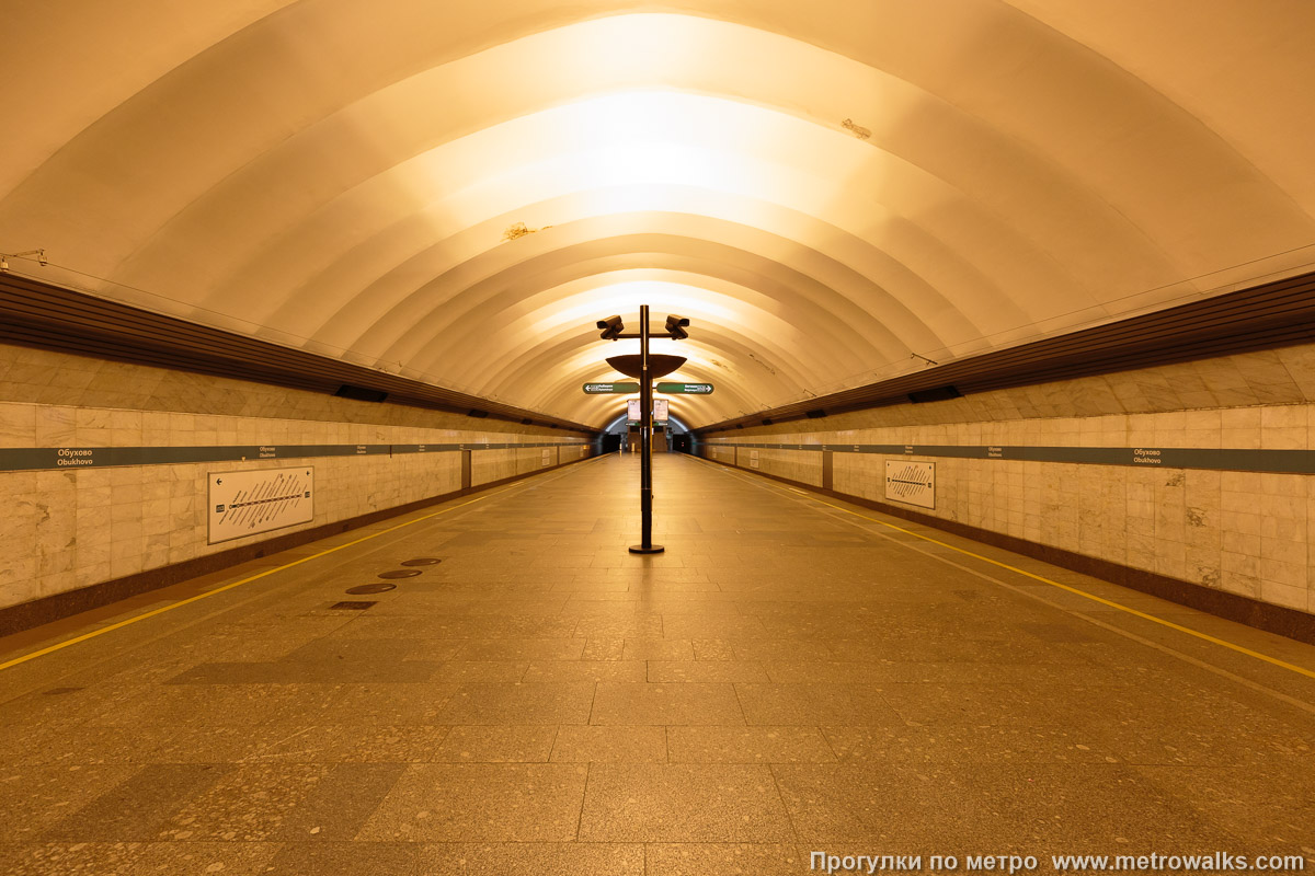 Фотография станции Обухово (Невско-Василеостровская линия, Санкт-Петербург). Общий вид по оси станции от входа в сторону глухого торца. Вариант облицовки с 2021 года.
