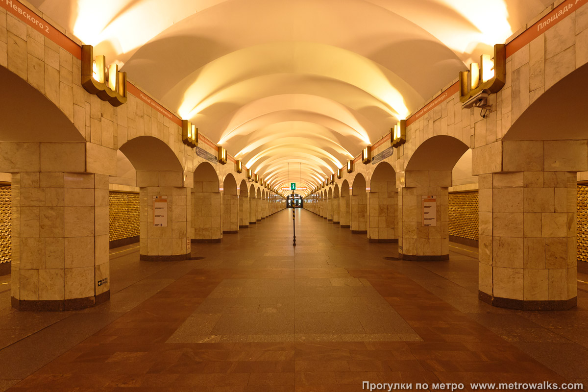 Фотография станции Площадь Александра Невского (Правобережная линия, Санкт-Петербург). Продольный вид центрального зала. С 2004 до 2021 года станция освещалась оранжевым натриевым светом.
