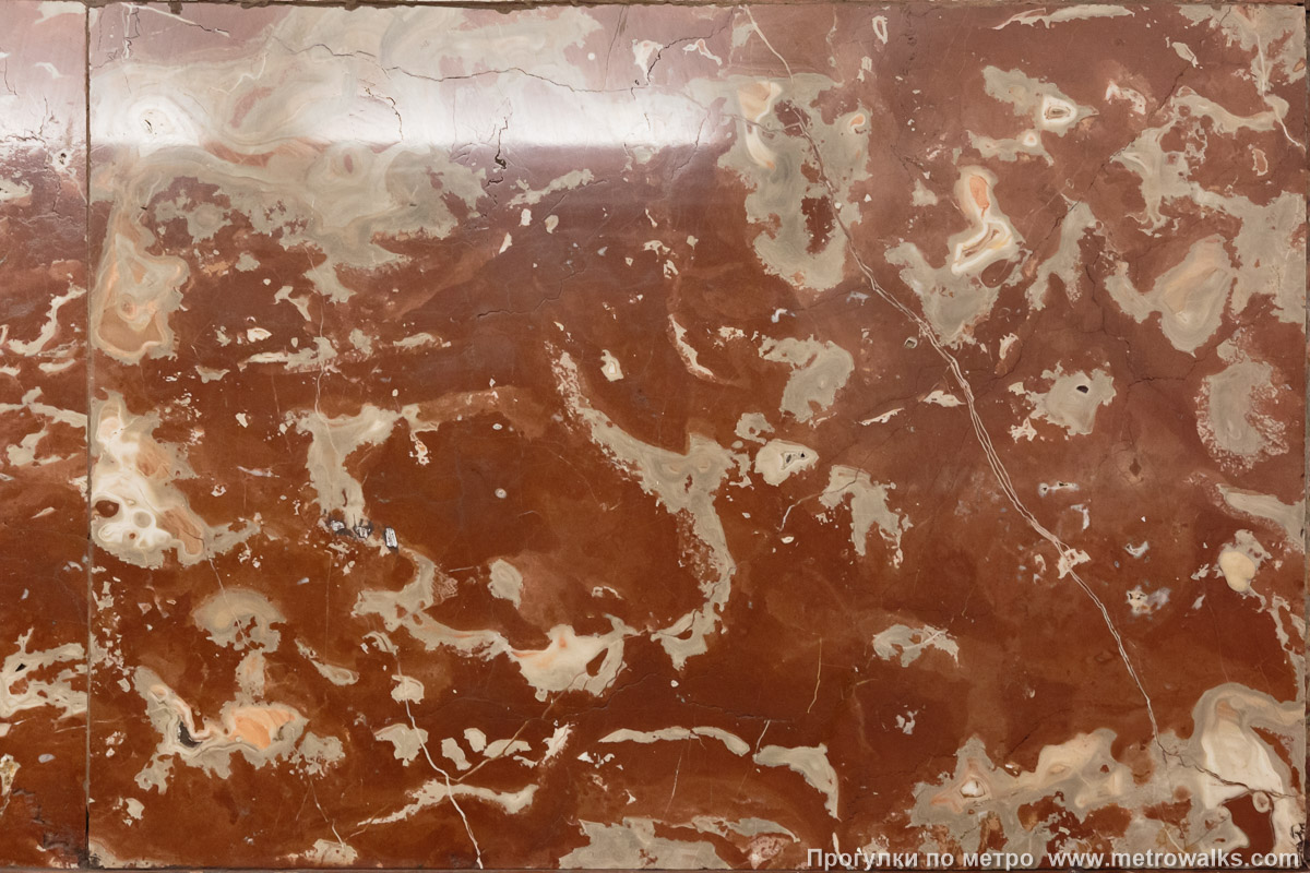 Фотография станции Площадь Ленина (Кировско-Выборгская линия, Санкт-Петербург). Крайние пилоны и фрагменты стен у обоих выходов облицованы красно-коричневым мрамором с белыми прожилками.