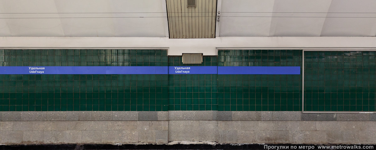 Фотография станции Удельная (Московско-Петроградская линия, Санкт-Петербург). Путевая стена. Раньше при рыжем свете было не очень заметно, что плитка — тёмно-зелёная, а не чёрная.