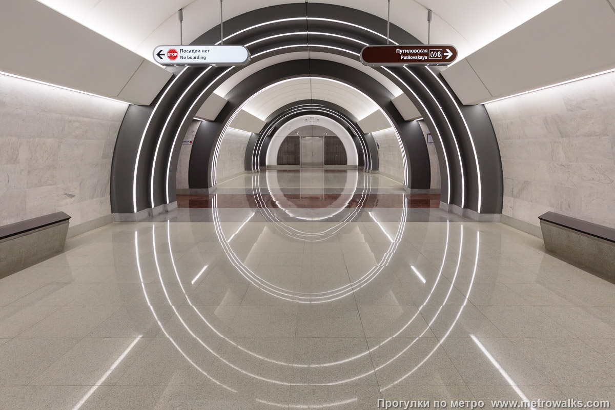 Фотография станции Юго-Западная (Красносельско-Калининская линия, Санкт-Петербург). Противоположная от входа часть станции. Взгляд вниз: обратите внимание на отражения световых арок, образующих яйцеобразные овалы.
