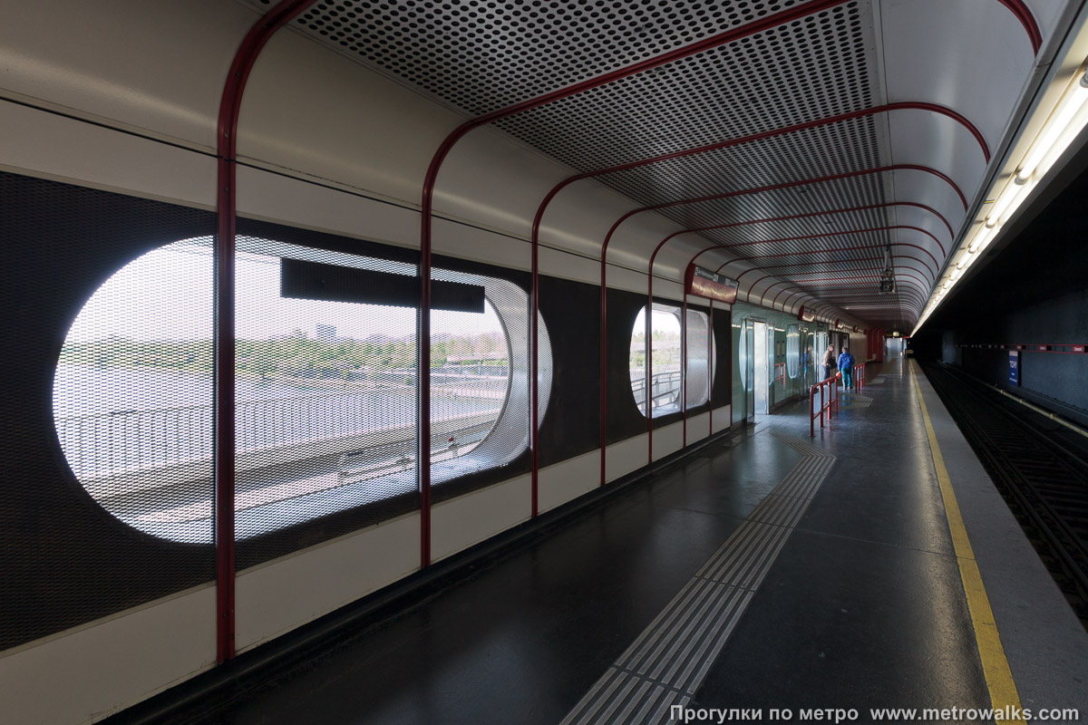 Фотография станции Donauinsel [Донауинзель] (U1, Вена). Продольный вид. Путь в сторону северо-восточной окраины. Поезда встречных направлений прибывают в отдельные залы, разделённые стеной.