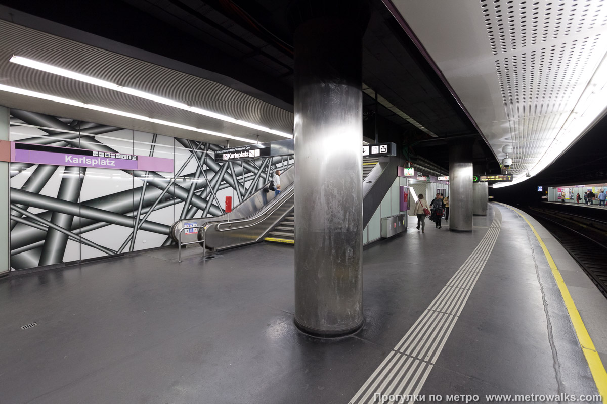 Фотография станции Karlsplatz [Карлсплац] (U2, Вена). Выход в город, эскалаторы начинаются прямо с уровня платформы. На заднем плане виден неприметный переход на линии U1 и U4.