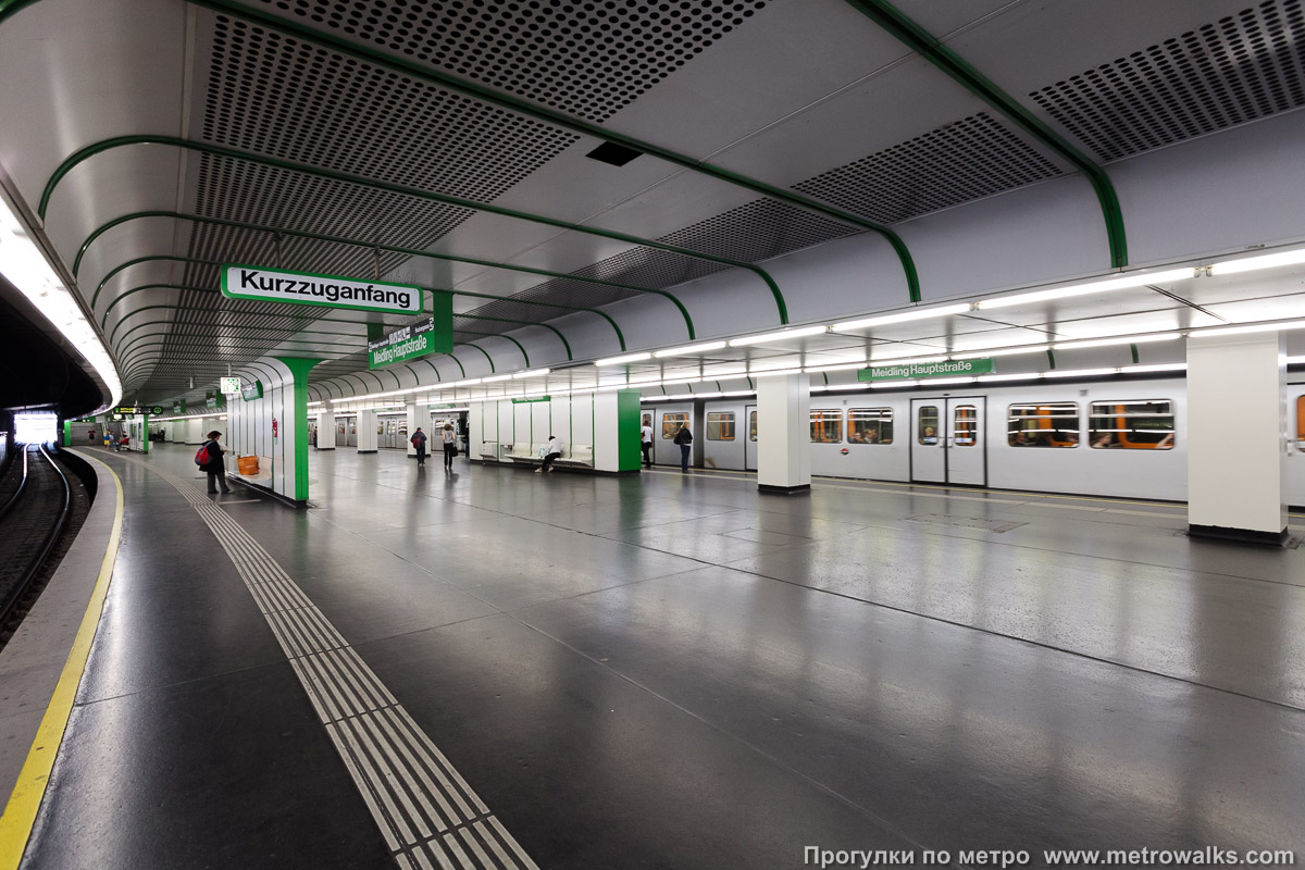 Фотография станции Meidling Hauptstraße [Майдлинг Хауптштрассе] (U4, Вена). Вид по диагонали. Вид с бесколонной половины станции на колонную. Для разнообразия — с поездом.