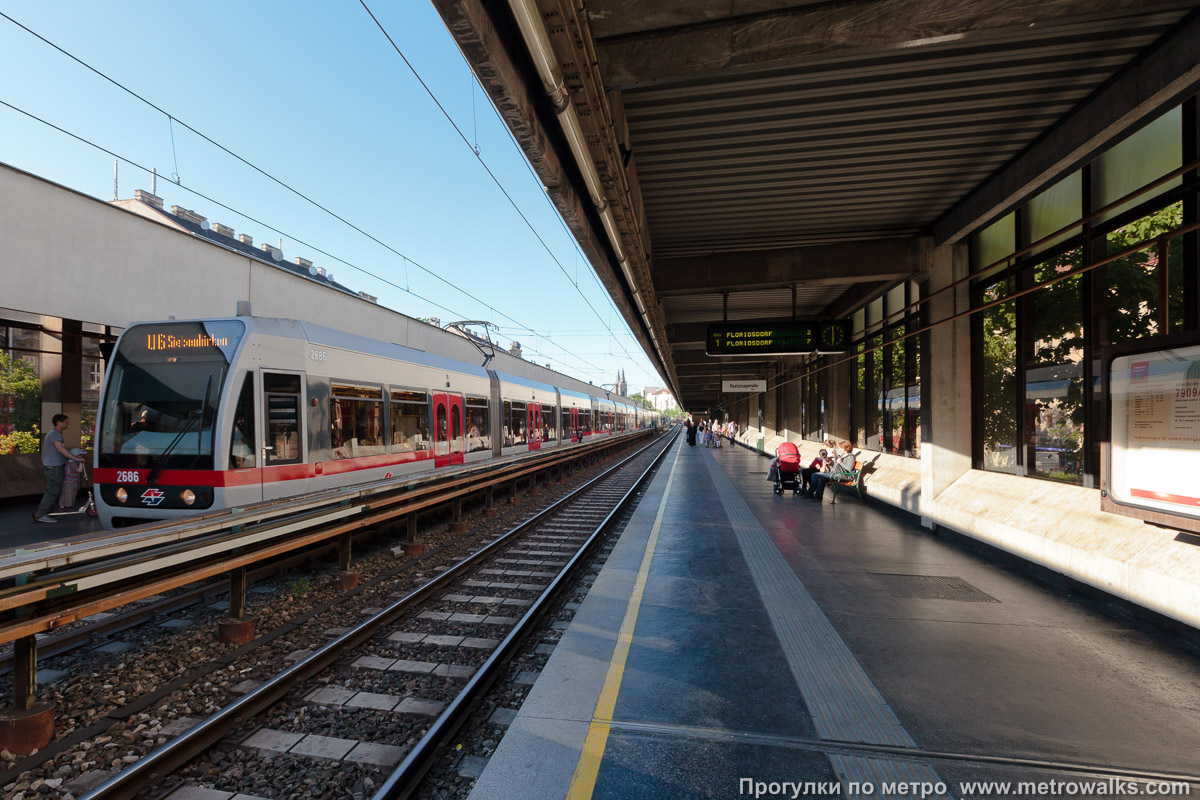 Фотография станции Thaliastraße [Талиаштрассе] (U6, Вена). Продольный вид вдоль края платформы. Для пущей цветастости — с поездом.